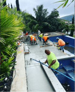 Concrete pool deck being poured by Hawaii pool builders.