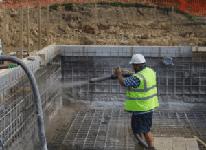 Oahu pool construction worker sprays gunite on the rebar.